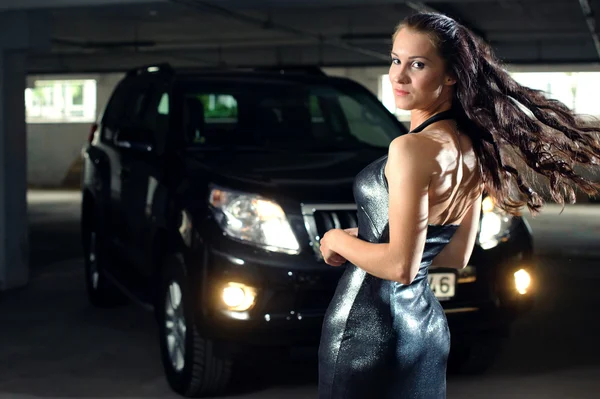 Flicka i ett underjordiskt garage med en bil — Stockfoto