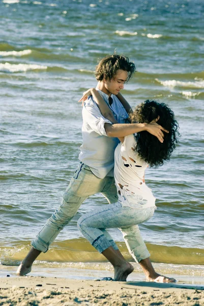 Pareja joven bailando tango en la playa —  Fotos de Stock