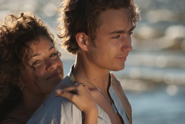 Un jeune couple sur le fond de la mer au coucher du soleil, profitant du temps — Photo