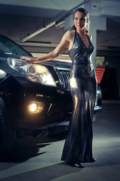 Girl in an underground garage with a car — Stock Photo, Image
