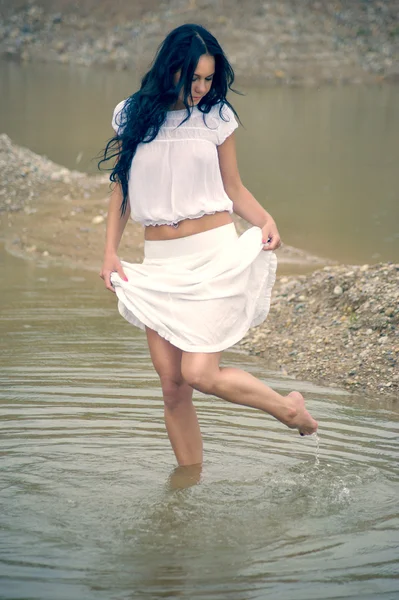 Menina sexy em branco andando no rio — Fotografia de Stock