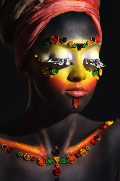 Afrikansk kvinde med kunstnerisk etnisk makeup på hendes ansigt og skuldre - Stock-foto