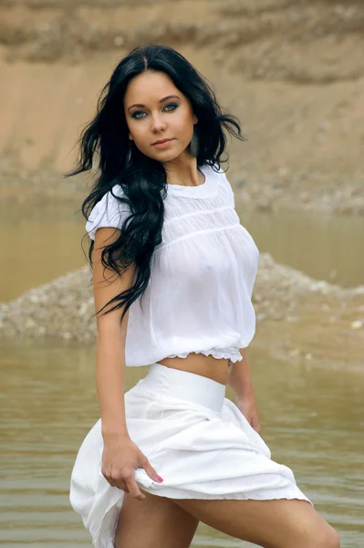 Sexy chica en blanco caminando en el río — Foto de Stock