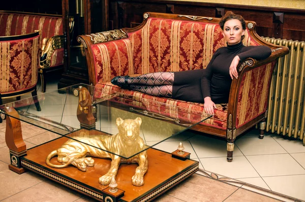 Жінка лежить на старовинному дивані — стокове фото