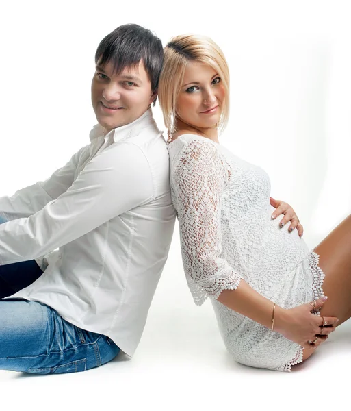 Zwangere vrouw met haar echtgenoot op wit — Stockfoto