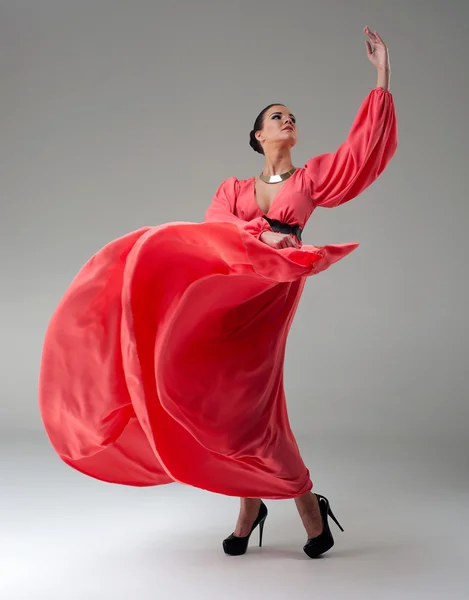 Girl in a long red dress dancing — Stock Photo, Image