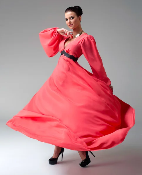 Girl in a long red dress dancing — Stock Photo, Image