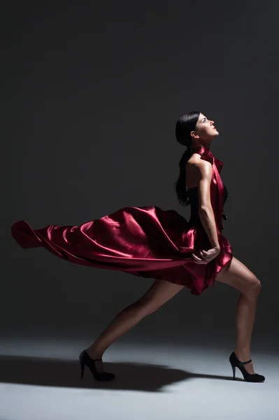 Young sexy dancing woman in red dress — Stock Photo, Image