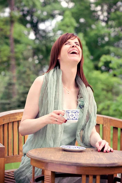 Gelukkige vrouw met koffie in de ochtend buitenshuis — Stockfoto