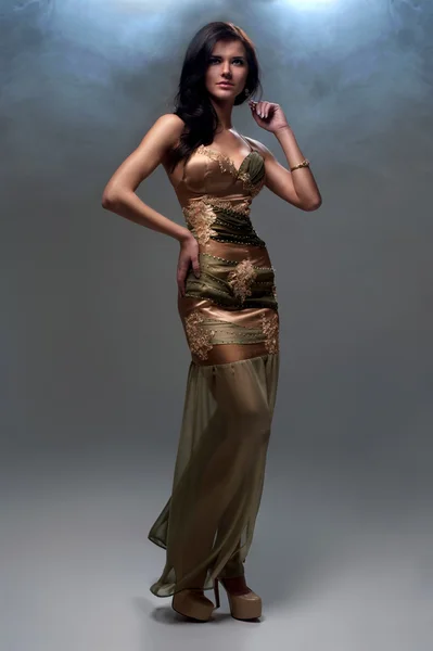 Жінка в золотисто-коричневій вечірній сукні — стокове фото