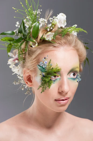 Young blond woman beauty portrait with wreath of flowers, studio shot Stock Photo