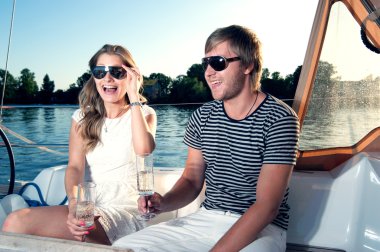 mutlu genç bir çift yatında şampanya içmek