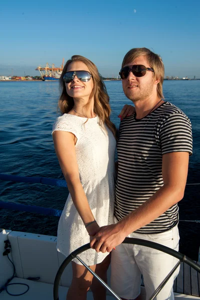 Young couple navigating on a yacht — Stock Photo, Image