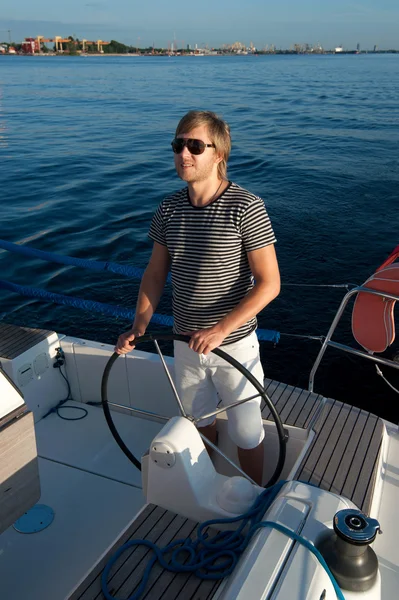 Szczęśliwy młody człowiek trzyma kierownicę jachtu — Zdjęcie stockowe