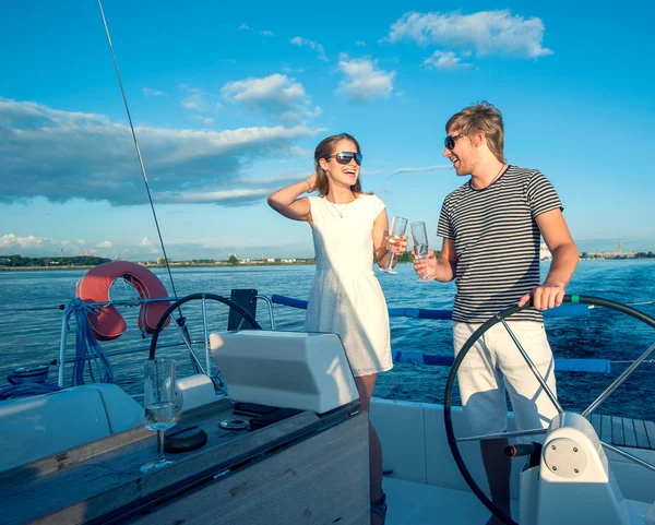 Щаслива молода пара п'є шампанське на яхті — стокове фото