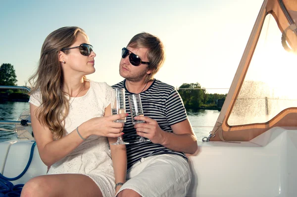 Felice giovane coppia bere champagne su yacht — Foto Stock