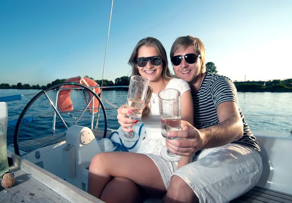 Happy young couple drinking champagne on yacht — Stock Photo, Image