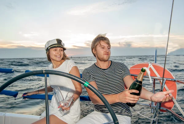 Щаслива молода пара п'є шампанське на яхті — стокове фото