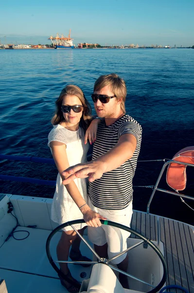 Young couple navigating on a yacht — Stock Photo, Image