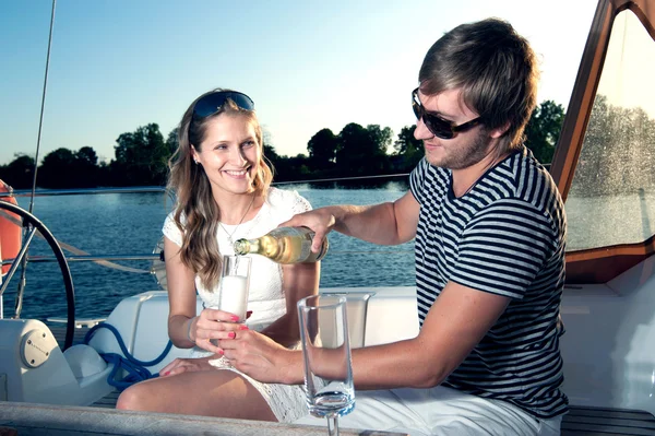 Lyckliga unga par dricka champagne på yacht — Stockfoto