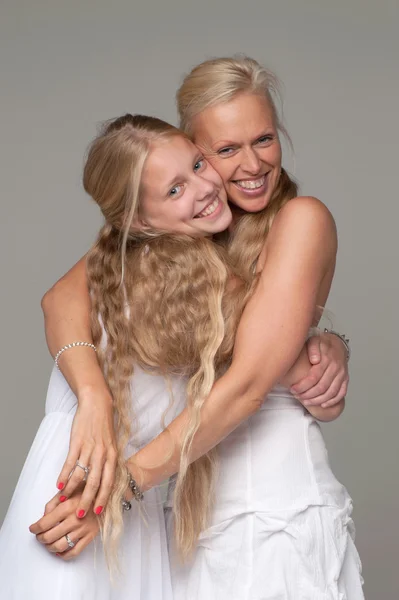 Beautiful mother and daughter posing in white dresses — Stock Photo, Image