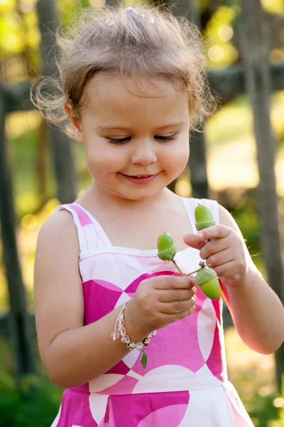 Cute little girl with acorns — Stock Photo, Image