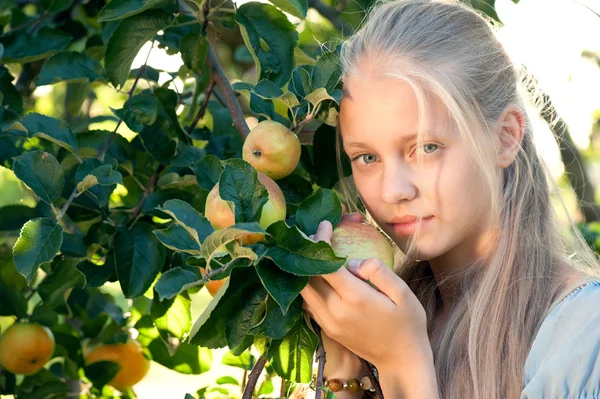 Outdoor portrait of beautiful blonde girl posing near apple tree — Stock Photo, Image