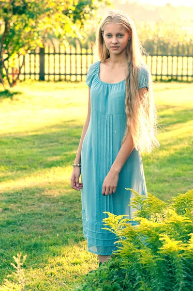 Beautiful young girl with long blond hair in blue dress in the countryside — Stock Photo, Image