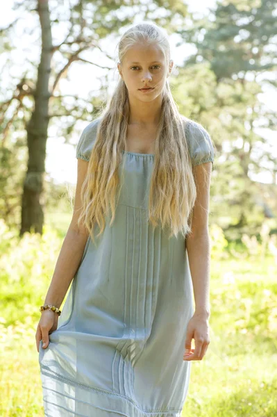 Beautiful young girl with long blond hair in blue dress in the countryside — Stock Photo, Image