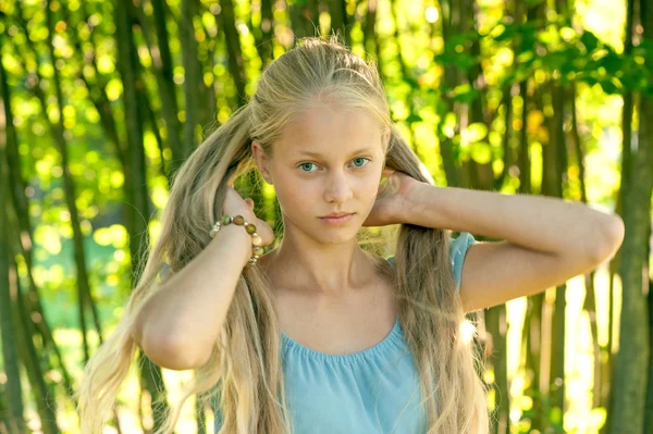 Vacker ung flicka med långa blonda hår i blå klänning på landsbygden — Stockfoto