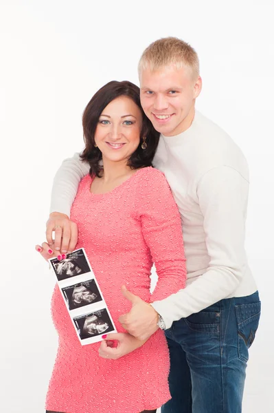 Happy pregnant woman with her husband showing ultrasound picture of baby — Stock Photo, Image