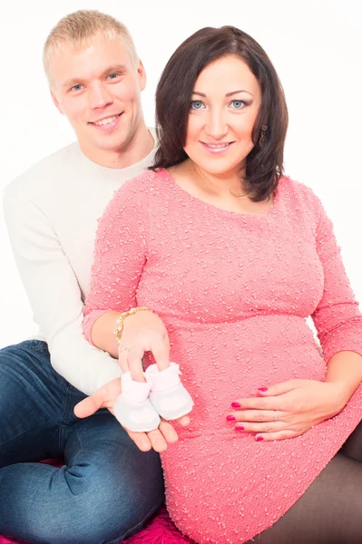 Pregnant woman and her husband with small baby shoes — Stock Photo, Image