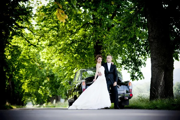 Bruid en bruidegom in auto — Stockfoto