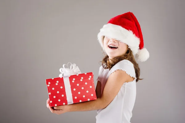 Small girl in santa hat with christmas gift — Stock Photo, Image