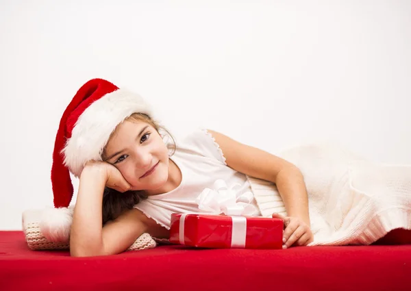 Bambina in cappello di Babbo Natale con regalo di Natale — Foto Stock