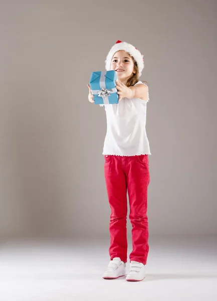 Small girl in santa hat with christmas gift — Stock Photo, Image