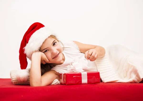Small girl in santa hat with christmas gift Royalty Free Stock Photos