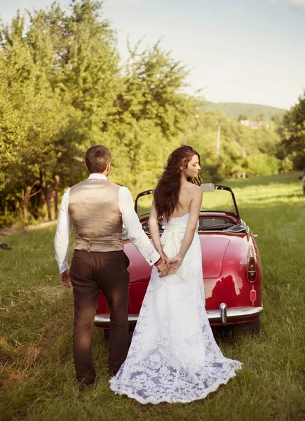 Svatební auto s nevěstou a ženichem — Stock fotografie