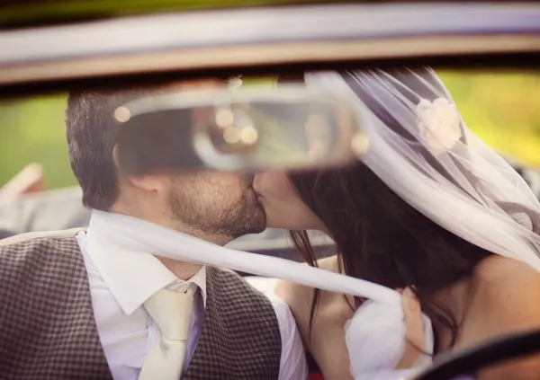 Bruiloft auto met bruid en bruidegom — Stockfoto