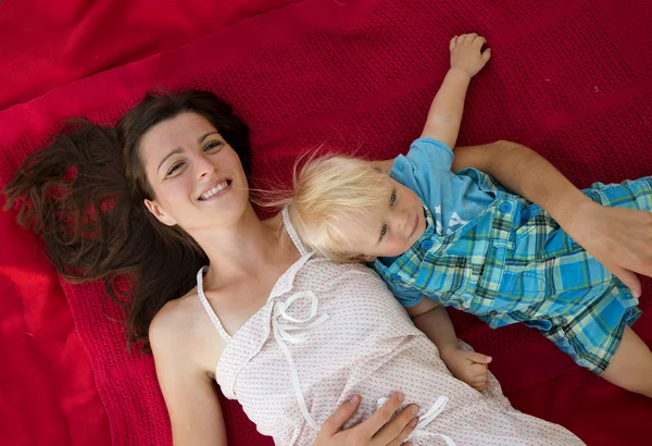 Mamma med son liggande på överkast — Stockfoto