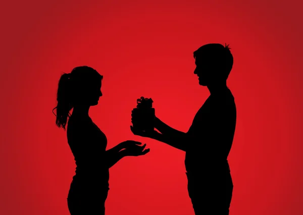 Silhouettes de couple avec cadeau — Photo