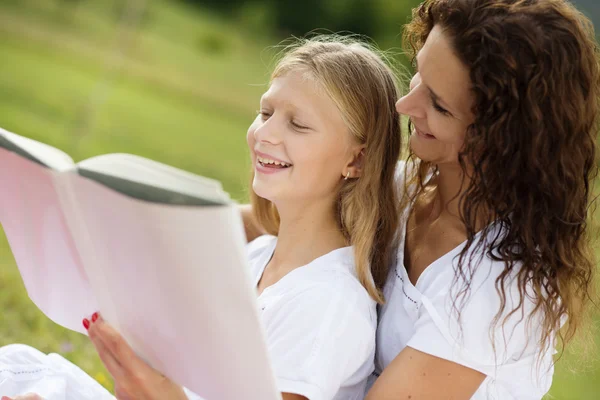 Mère et enfants lisant un livre — Photo