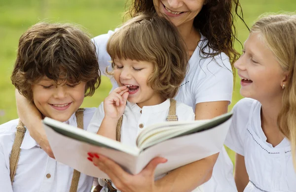 Madre e figli che leggono un libro — Foto Stock