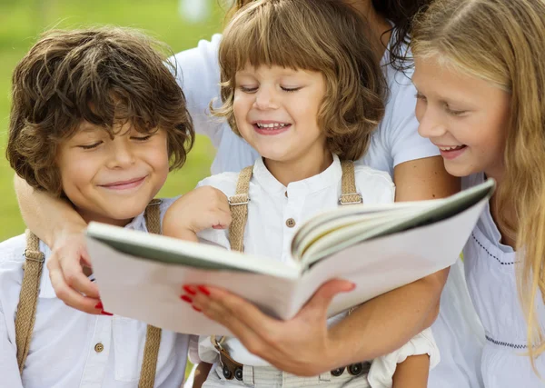 Matka a děti čtení knihy — Stock fotografie