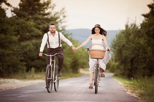 Bruid en bruidegom op de fietsen — Stockfoto