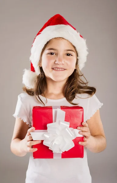 Liten flicka i santa mössa med julklapp — Stockfoto