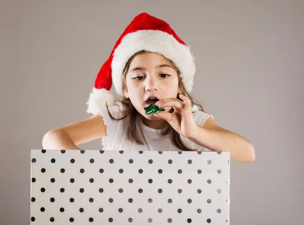 Klein meisje in Kerstman hoed met de gift van Kerstmis — Stockfoto