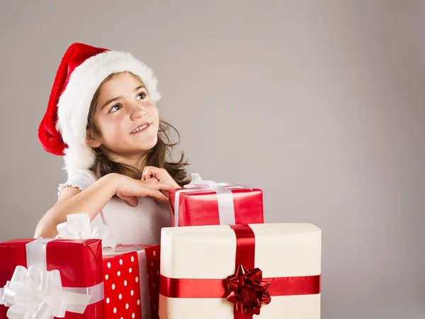 Petite fille en chapeau de Père Noël avec cadeau de Noël — Photo
