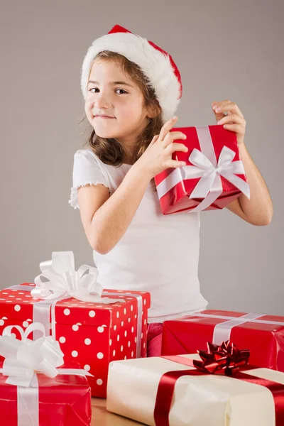 Liten flicka i santa mössa med julklapp — Stockfoto