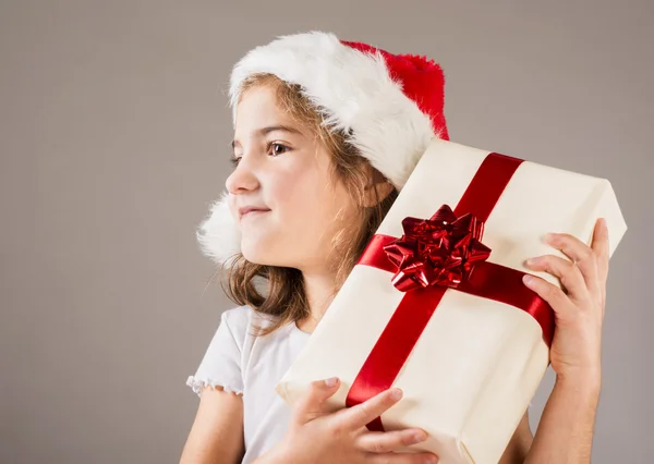 Petite fille en chapeau de Père Noël avec cadeau de Noël — Photo